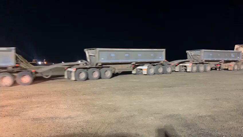 Road trains under lights at night